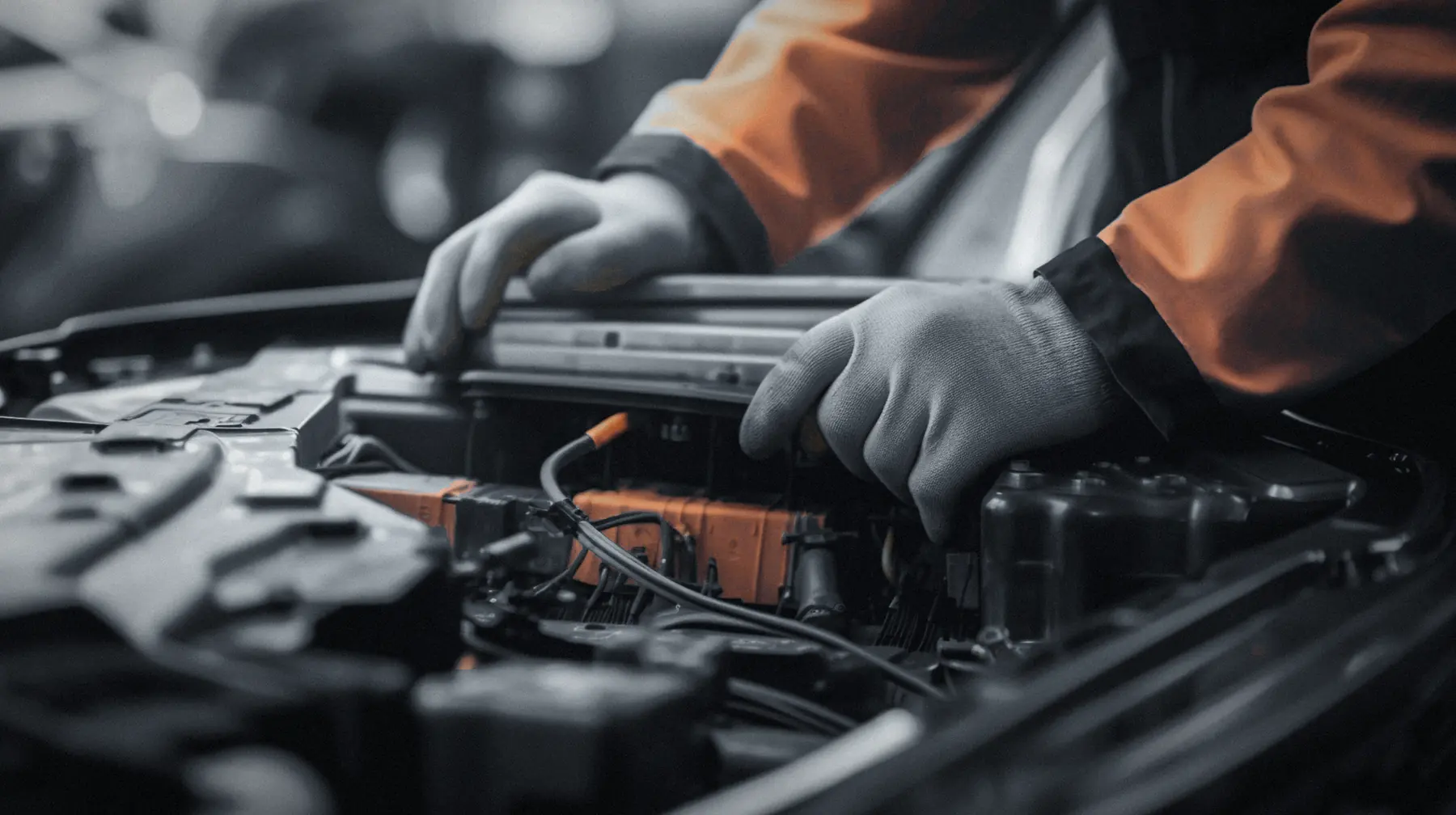Mãos com luvas trabalhando no compartimento do motor de um carro